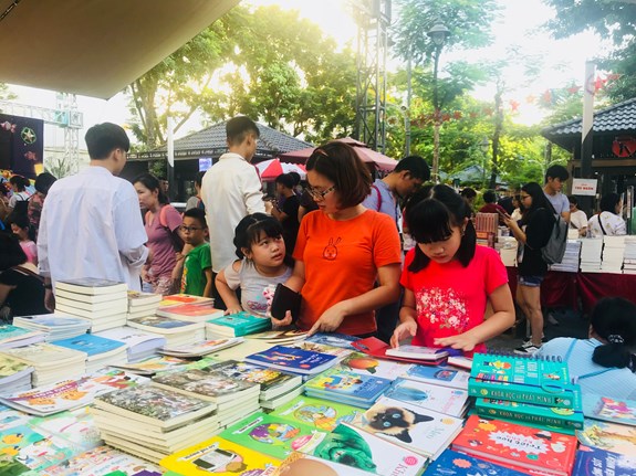 Các em nhỏ và phụ huynh chọn sách tại “Hội sách trăng tròn”.